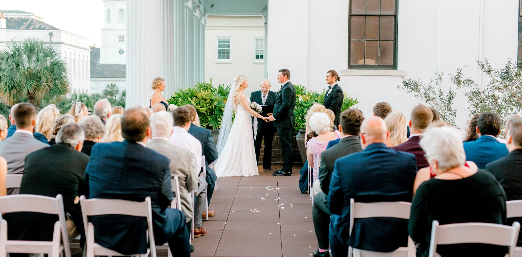 Bride & Groom with minister in front of group of people