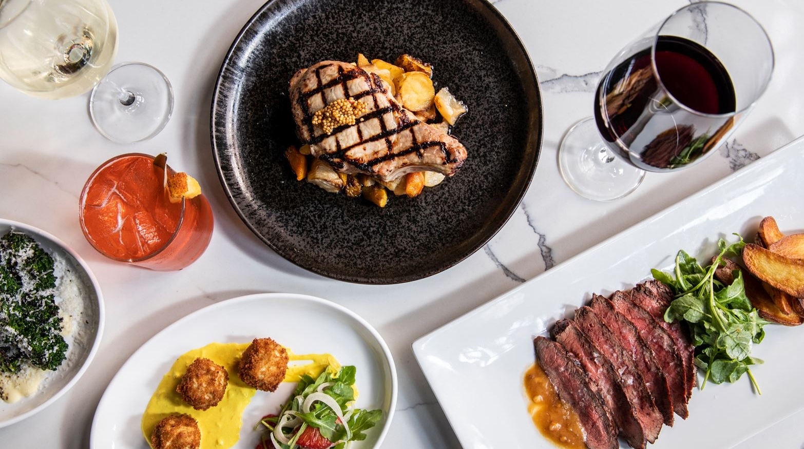 Spread of dinner dishes and cocktails on a table