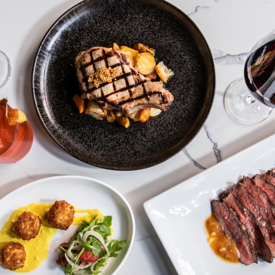 Spread of dinner dishes and cocktails on a table